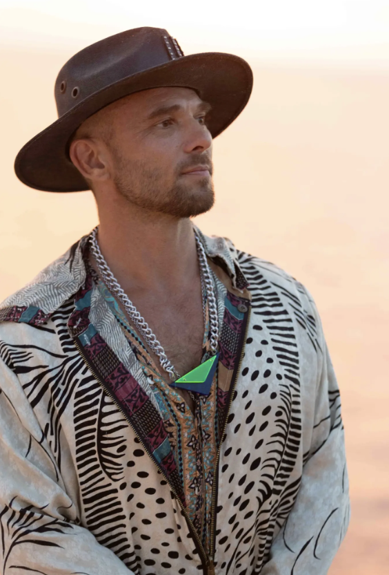 Spooky looking toward the horizon in warm light, wearing the neon-green pendant.