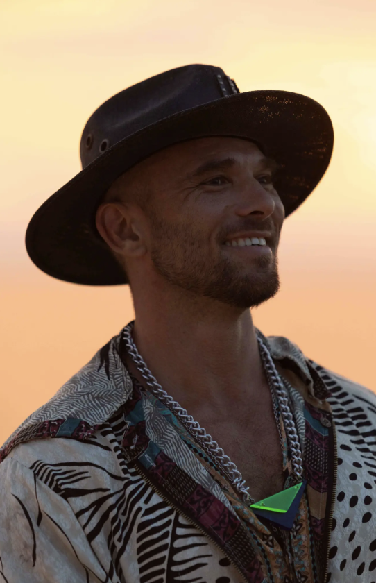 Spooky smiling in a black hat and patterned shirt in warm evening light.